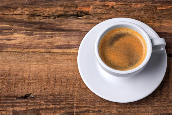 Una taza de café en una mesa de madera. Fondo oscuro . —  Fotos de Stock