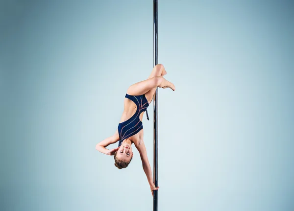 Het sterke en gracieuze jonge meisje uitvoeren van acrobatische oefeningen op een pylon — Stockfoto