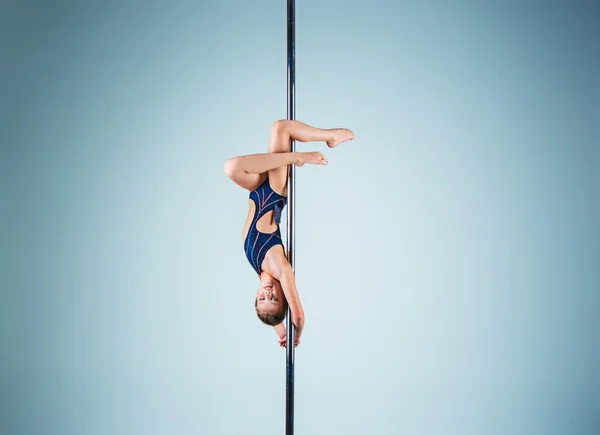 Het sterke en gracieuze jonge meisje uitvoeren van acrobatische oefeningen op een pylon — Stockfoto