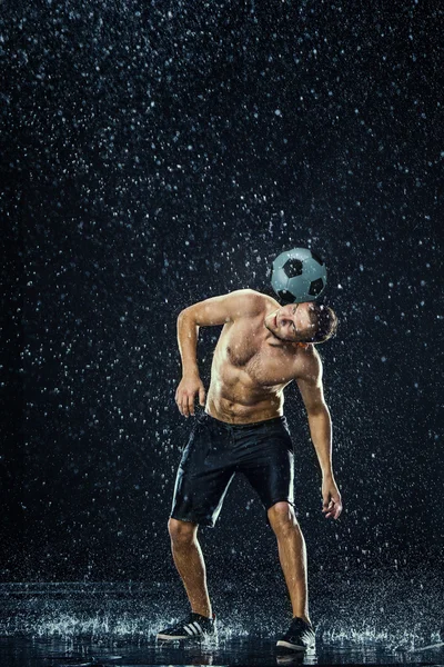 Gocce d'acqua intorno al giocatore di calcio — Foto Stock