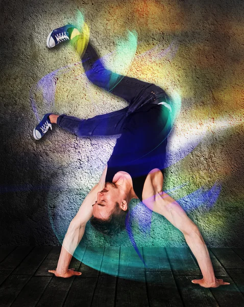 Break dançarina fazendo suporte de mão contra fundo de parede colorido — Fotografia de Stock