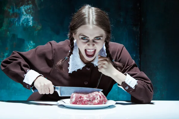 Кровавый Хэллоуин тема: сумасшедшая девушка с ножом, вилкой и мясом — стоковое фото