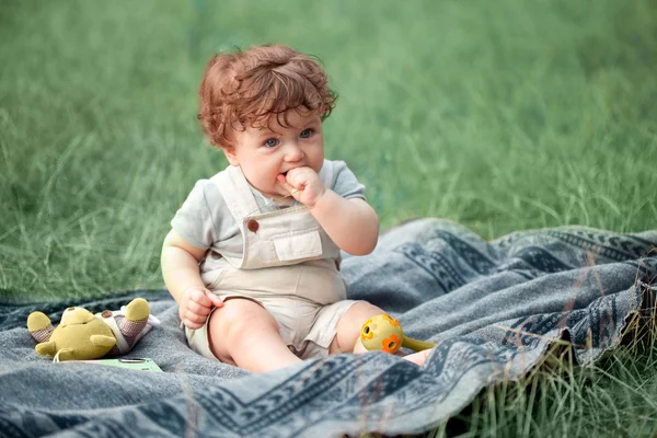 O bebê pequeno ou criança de ano na grama no dia ensolarado de verão . — Fotografia de Stock