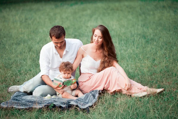 Junge schöne Vater, Mutter und kleine Kleinkind Sohn gegen grüne Bäume — Stockfoto