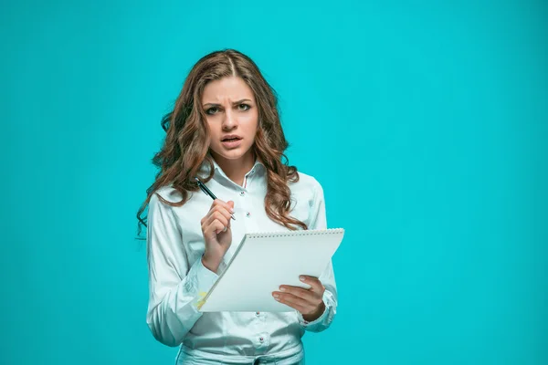 La giovane donna d'affari premurosa con penna e tablet per appunti su sfondo blu — Foto Stock