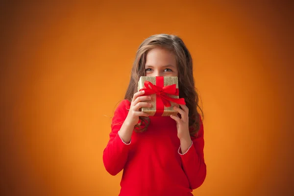 Das süße fröhliche kleine Mädchen auf orangefarbenem Hintergrund — Stockfoto