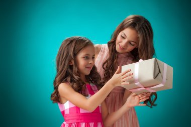 İki sevimli neşeli küçük kız mavi zemin üzerine