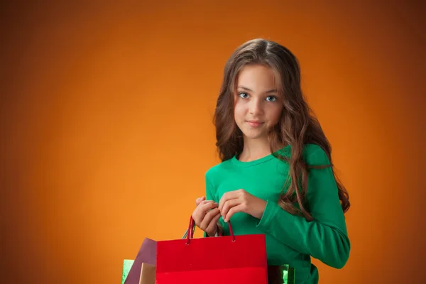 Милая веселая маленькая девочка с сумками для покупок — стоковое фото