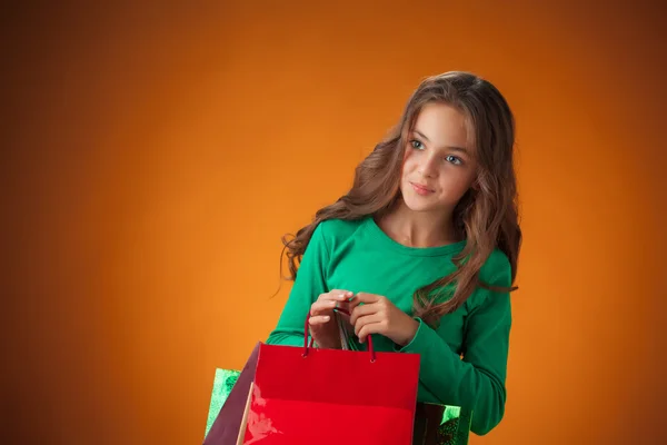 Das süße fröhliche kleine Mädchen mit Einkaufstaschen — Stockfoto