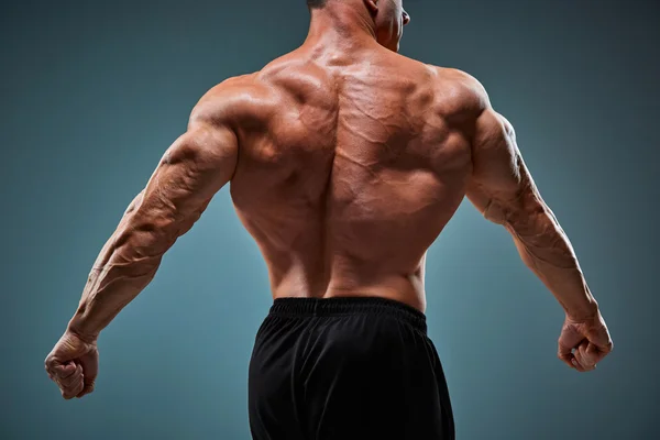 Torso of attractive male body builder on gray background. — Stock Photo, Image