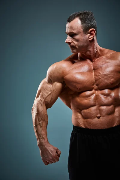 Torso de constructor de cuerpo masculino atractivo sobre fondo gris . —  Fotos de Stock