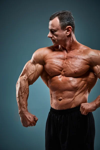 Torso de construtor de corpo masculino atraente no fundo cinza . — Fotografia de Stock