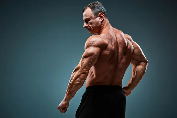 Torso de constructor de cuerpo masculino atractivo sobre fondo gris . — Foto de Stock