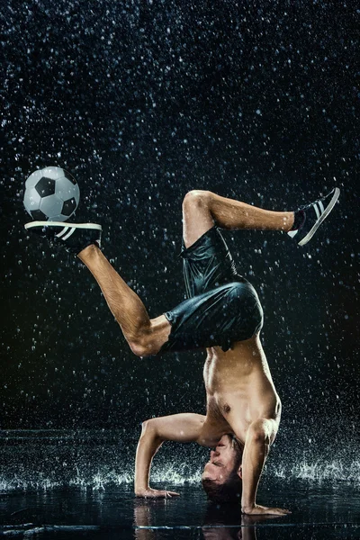 Waterdruppels rond voetballer — Stockfoto