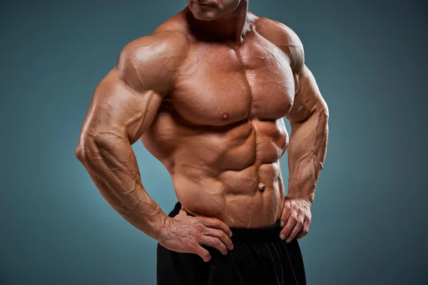 Torso de constructor de cuerpo masculino atractivo sobre fondo gris . — Foto de Stock