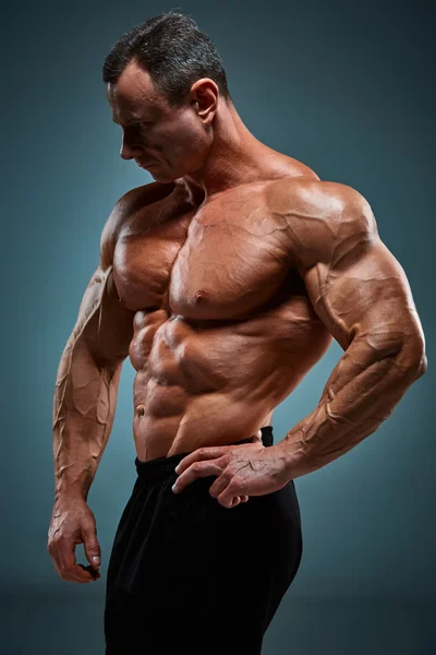 Torso de constructor de cuerpo masculino atractivo sobre fondo gris . —  Fotos de Stock