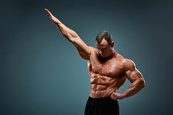 Torso de constructor de cuerpo masculino atractivo sobre fondo gris . — Foto de Stock