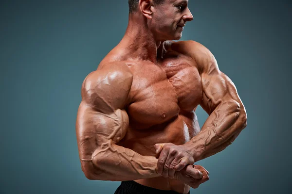 Torso de construtor de corpo masculino atraente no fundo cinza . — Fotografia de Stock