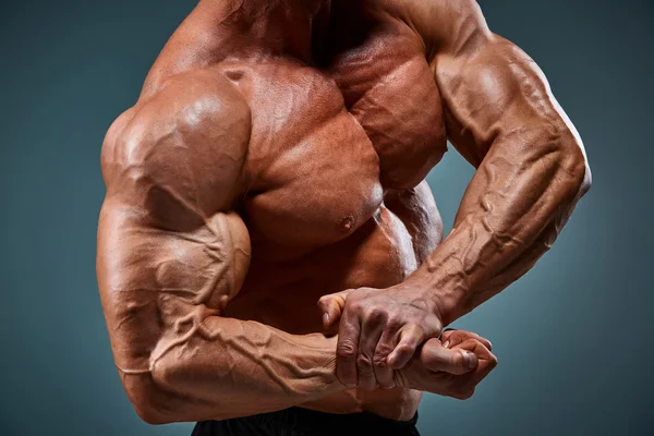 Oberkörper eines attraktiven männlichen Bodybuilders auf grauem Hintergrund. — Stockfoto