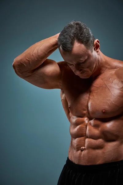 Torso de constructor de cuerpo masculino atractivo sobre fondo gris . —  Fotos de Stock