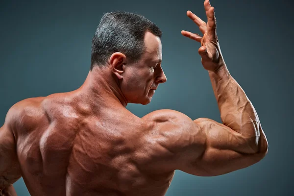 Torso of attractive male body builder on gray background. — Stock Photo, Image