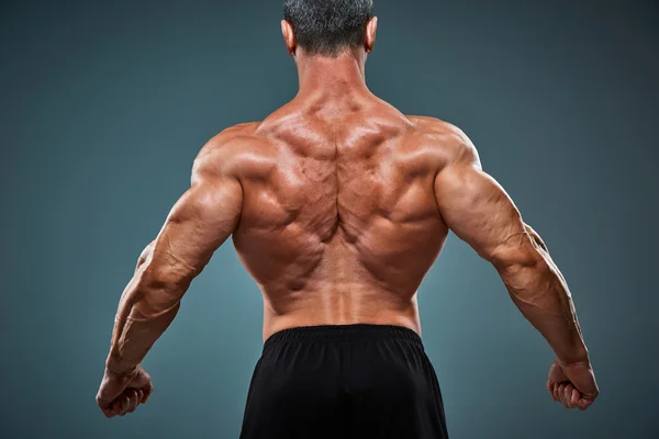 Torso de constructor de cuerpo masculino atractivo sobre fondo gris . — Foto de Stock