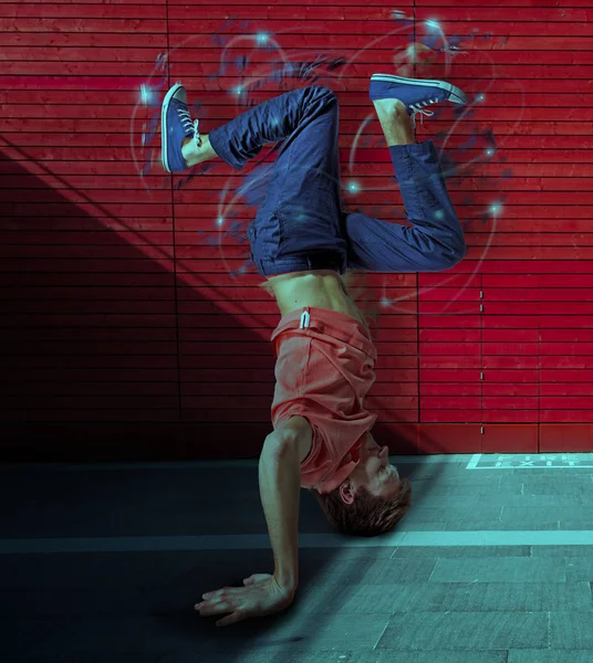 Break dancer doing handstand against colorful wall background — Stock Photo, Image