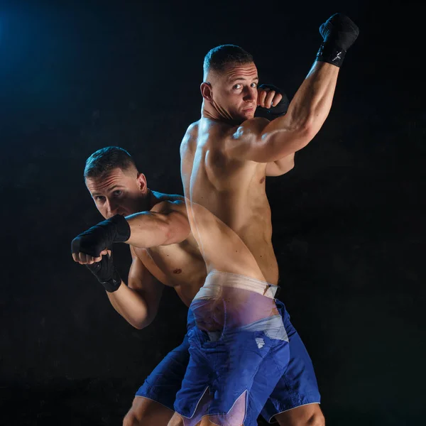 Boxer masculino boxe em um estúdio escuro — Fotografia de Stock