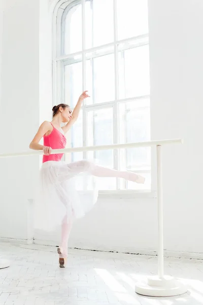 Ballerina posiert in Spitzenschuhen vor weißem Holzpavillon — Stockfoto