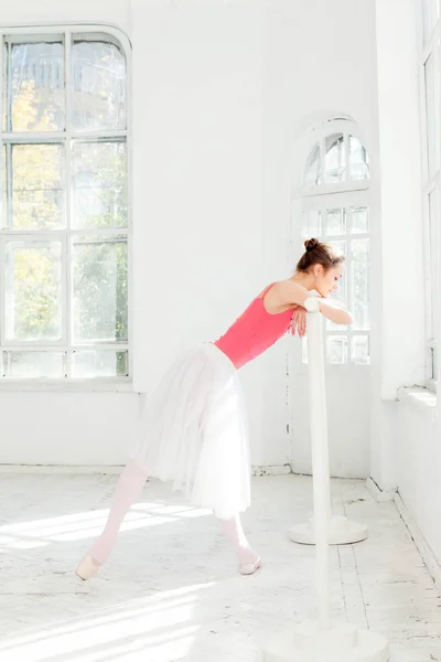 Baletka pózuje v pointe boty na bílý dřevěný pavilon — Stock fotografie