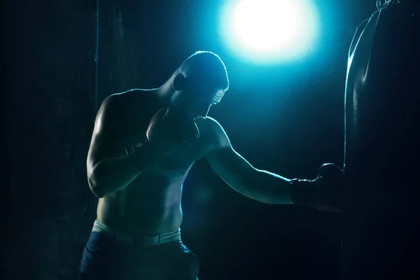 Male boxer boxing in punching bag — Stock Photo, Image