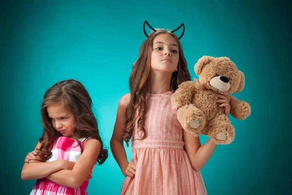 两个可爱的小女孩的玩具熊的蓝色背景上 — 图库照片