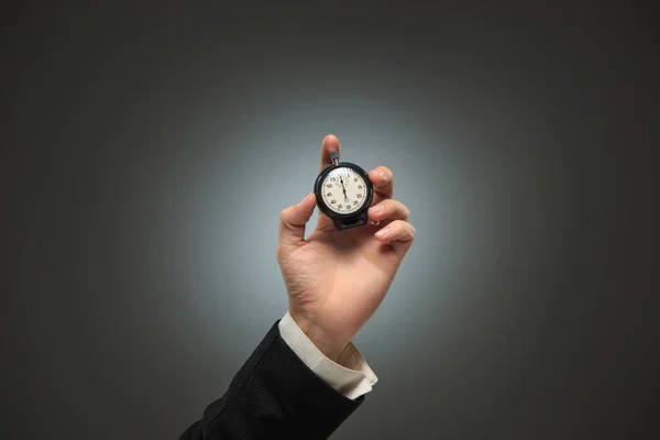 Hand met een stopwatch tegen een witte achtergrond — Stockfoto