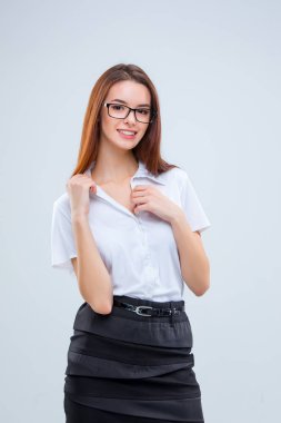 Gri arka plan üzerinde gülümseyen genç iş kadını