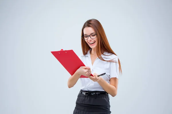 The smiling young business woman with pen and tablet for notes on gray background