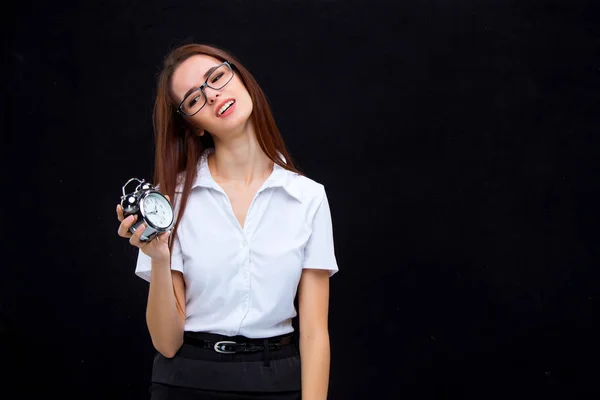 Tânăra femeie de afaceri cu ceas deșteptător pe fundal negru — Fotografie, imagine de stoc