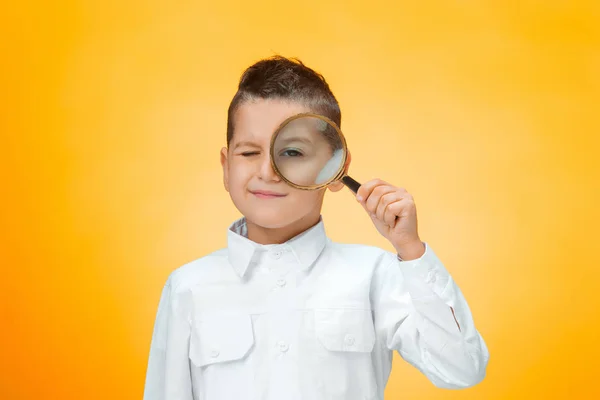 Little boy using magnifier looking close up — Stock Photo, Image