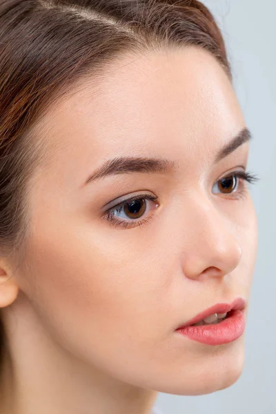 El rostro de la mujer sobre fondo gris — Foto de Stock