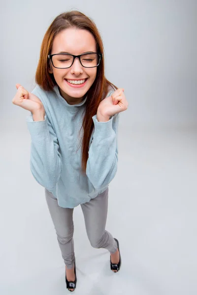 De lachende jonge zakenvrouw op grijze achtergrond — Stockfoto