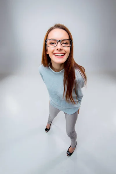 De lachende jonge zakenvrouw op grijze achtergrond — Stockfoto