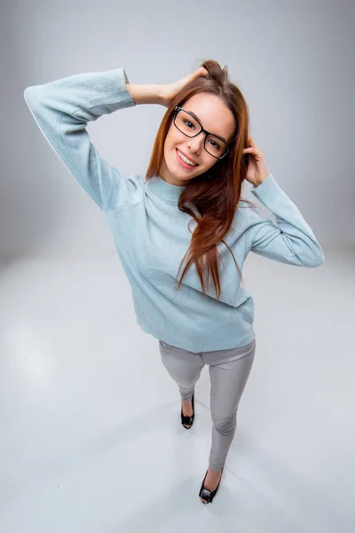 Die lächelnde junge Geschäftsfrau auf grauem Hintergrund — Stockfoto