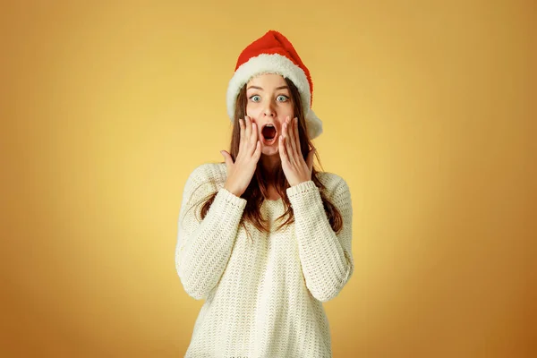 Překvapený vánoční dívka, která nosí klobouk santa — Stock fotografie