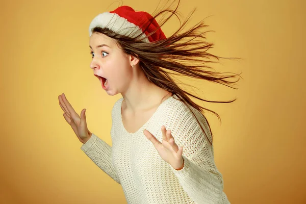 Sorpresa ragazza di Natale indossa un cappello di Babbo Natale — Foto Stock