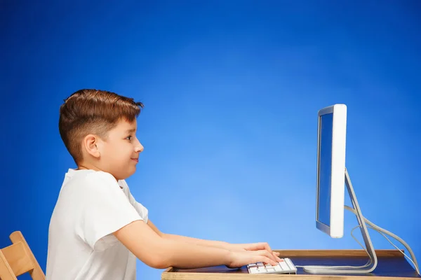 坐在监视器笔记本电脑在工作室前的入学年龄男孩 — 图库照片