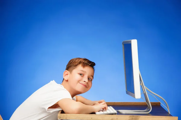Хлопчик шкільного віку сидить перед ноутбуком монітора в студії — стокове фото