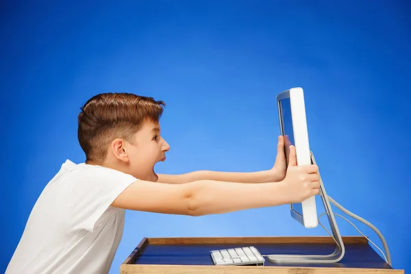 School-leeftijd jongen zit van de monitor laptop in studio — Stockfoto