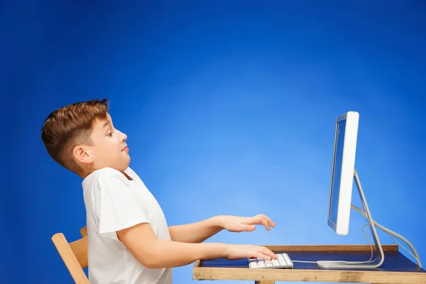 School-leeftijd jongen zit van de monitor laptop in studio — Stockfoto
