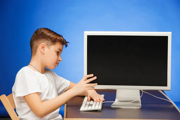 学校年龄男孩坐在工作室的显示器笔记本电脑 — 图库照片