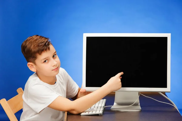 School-leeftijd jongen zitten met de monitor laptop in studio — Stockfoto