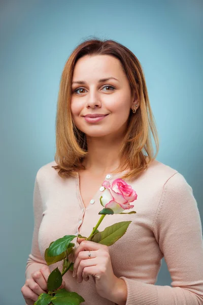 Young woman holding rose and smiling